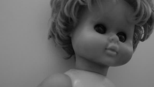 Creepy baby doll, black  and white, grunge, noise and grainy darkness.