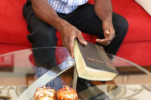 A black man holding a Bible in his hand