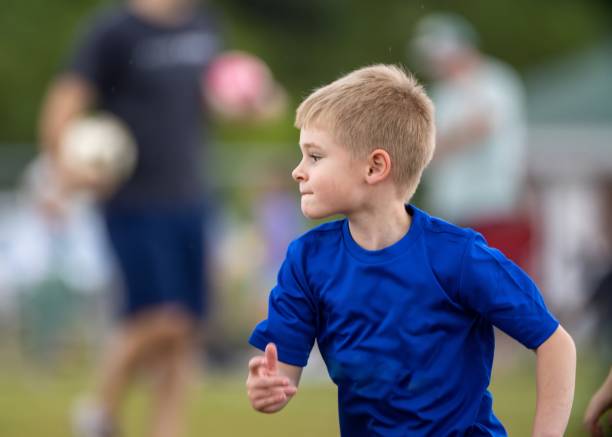menino que joga futebol de equipe em uniforme azul - sports uniform blue team event sports activity - fotografias e filmes do acervo