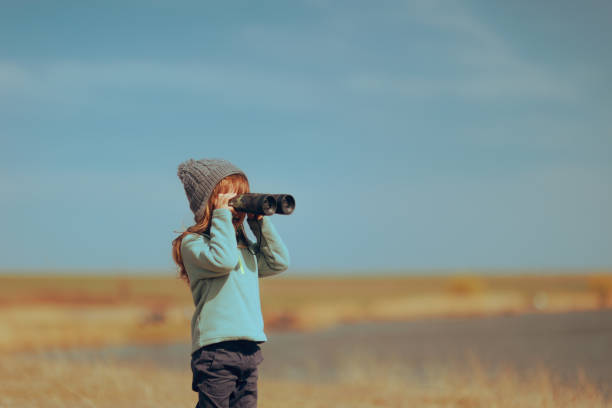 istock Little Girl using a Binocular Checking Nature Outdoors 1486412274