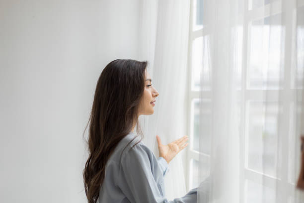 Young Woman Delighted by Scenery as Opens Window Curtains at Morning