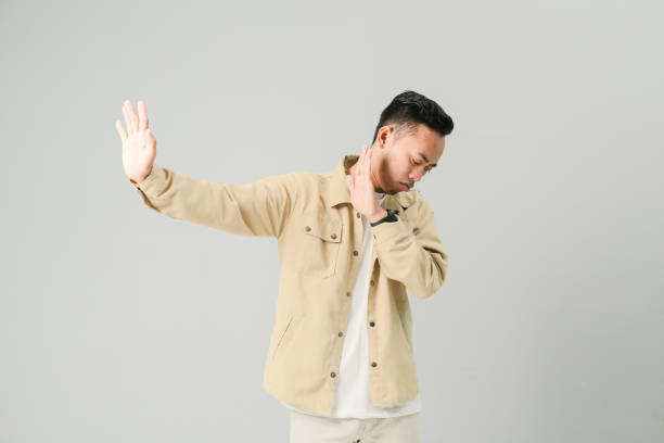 istock a young asian showing a prohibition gesture, isolated on gray background 1486417656