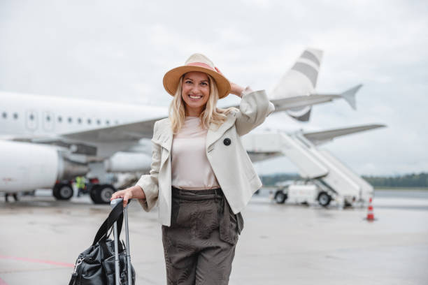 touriste souriante devant un avion - airport passengers photos et images de collection