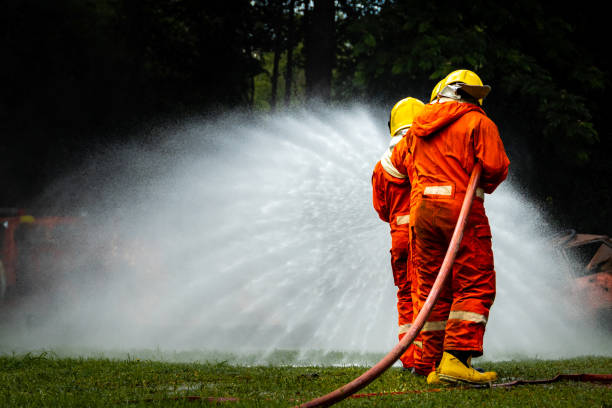 istock Firefighter Concept. Fireman using water and extinguisher to fighting with fire flame. firefighters fighting a fire with a hose and water during a firefighting training exercise 1486428349
