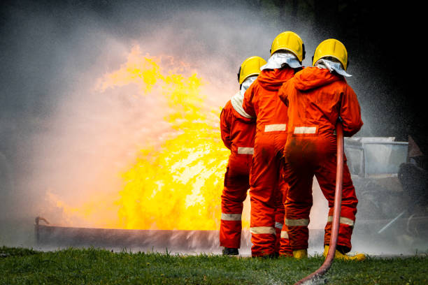 istock Firefighter Concept. Fireman using water and extinguisher to fighting with fire flame. firefighters fighting a fire with a hose and water during a firefighting training exercise 1486428352