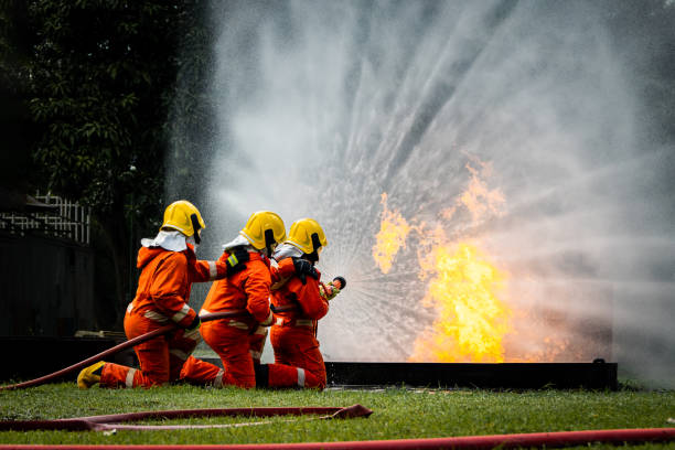 istock Firefighter Concept. Fireman using water and extinguisher to fighting with fire flame. firefighters fighting a fire with a hose and water during a firefighting training exercise 1486428403