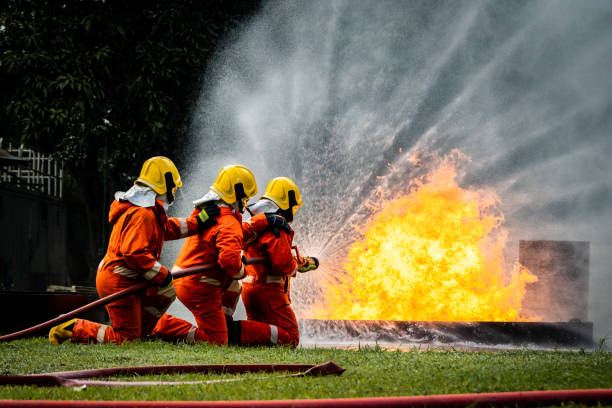 istock Firefighter Concept. Fireman using water and extinguisher to fighting with fire flame. firefighters fighting a fire with a hose and water during a firefighting training exercise 1486428405