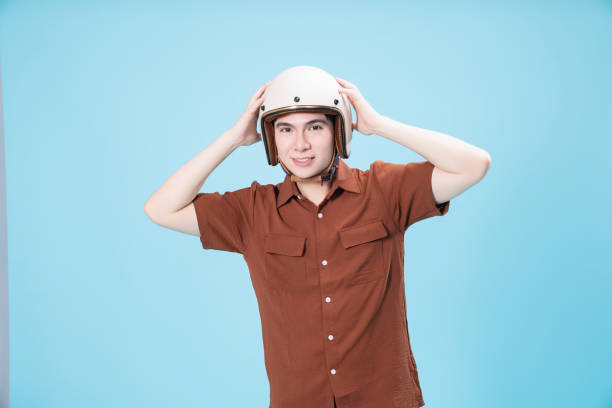 istock Young Asian man wearing helmet on background 1486428438