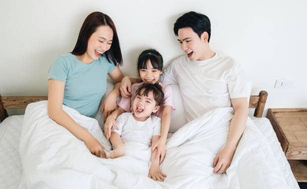 istock Young Asian family on bed 1486433422