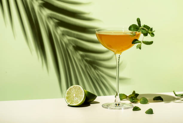 old cuban alcoholic cocktail drink with white rum, lime juice, sparkling wine, syrup, bitter, mint and ice. lime green background, hard light, shadow pattern - lime imagens e fotografias de stock