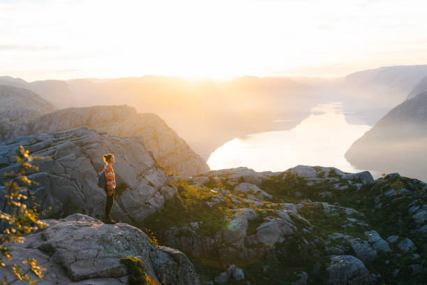 istock Woman standing on Preikestolen and looking at view 1486450756