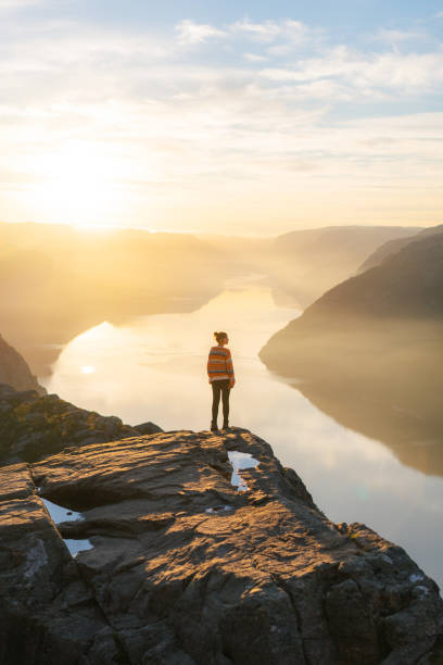 donna in piedi su preikestolen e guardando la vista - norwegian culture foto e immagini stock