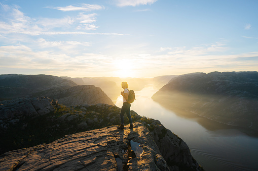 Caucasian man looking at scenic view of Lysefjorden from  Preikestolen at sunrise