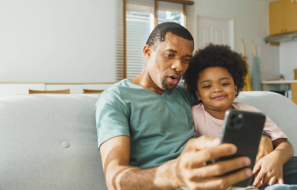 istock Smiling African American father and his cute boy taking selfies. 1486456076