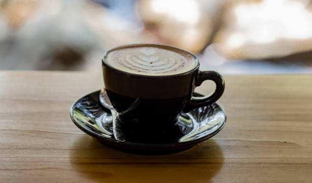 istock Hot coffee in black cup and blurred nature background. 1486457390