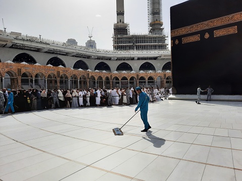 The cleaning crew is cleaning the courtyard of Masjid al-Haram during the day.