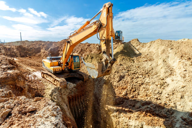 istock Two Excavator are digging soil in the construction site on sky background,with white fluffy cloud 1486470369