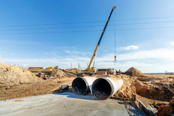 istock Connecting a trench drain to a concrete manhole structure at construction site. Concrete pile in formwork frame for construct stormwater and underground utilities, pump stations, sewers pipes 1486470393