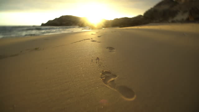 Footprints of bare feet in the sand on the beach near the sea