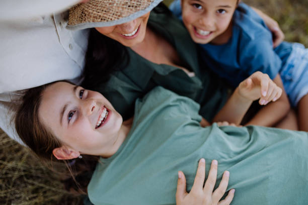 istock Portrait of happy, affectionate mother and her daughters hugging during sunset. 1486475767
