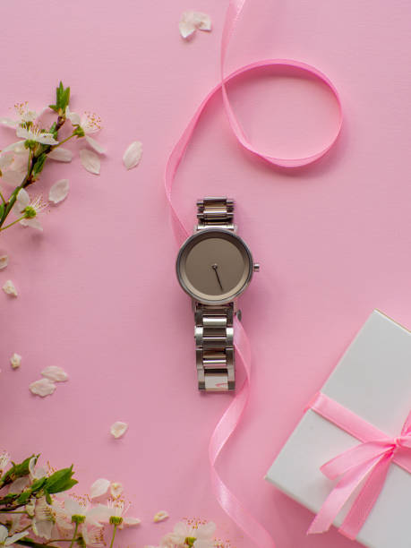 istock Womens wristwatch on pink background with cherry flowers and copy space 1486476343