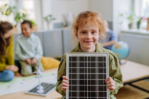 istock Little girl posing with solar panel during a school lesson. 1486481427