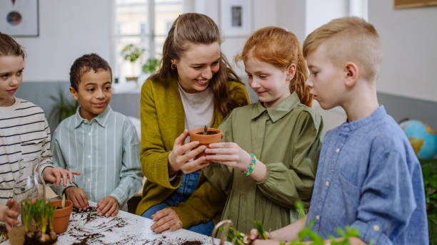 istock Young teacher learning pupils how to take care about plants. 1486481465