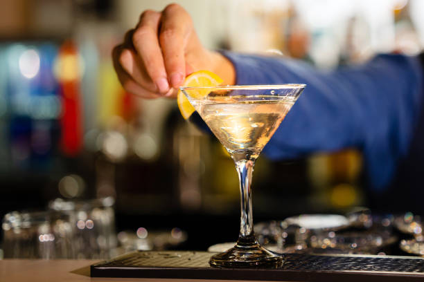 istock Hand of bartender garnishing a cocktail with lemon 1486483945