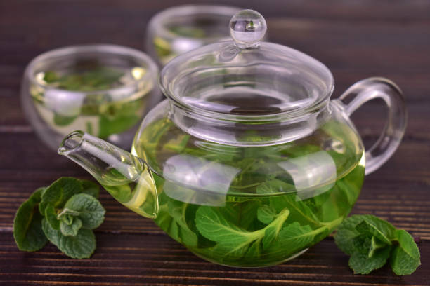 istock Teapot with mint tea on a dark wooden background. 1486488108