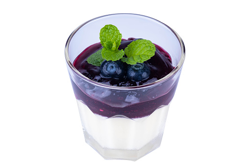 Blueberry Panna Cotta in a clear glass Top with fresh blueberries and mint leaf , isolated on white background with clipping path