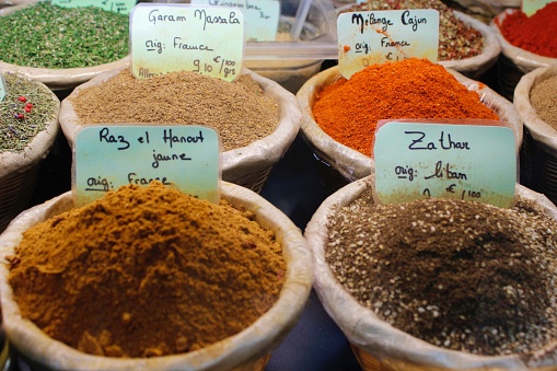Set os bowls with spices powder and herbs. Turmeric, curry, Provence herbs, paprika, nutmeg, cajun. Image of a market selling bags with condiments and seasonings from exotic and international origins.