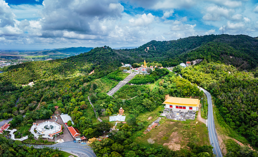 Aerial drone Of the beautiful Buddha statue on the hill (on top of mountain). At Hatyai, Songkhla, Thailand. The attitude of persuading the relatives not to quarrel.