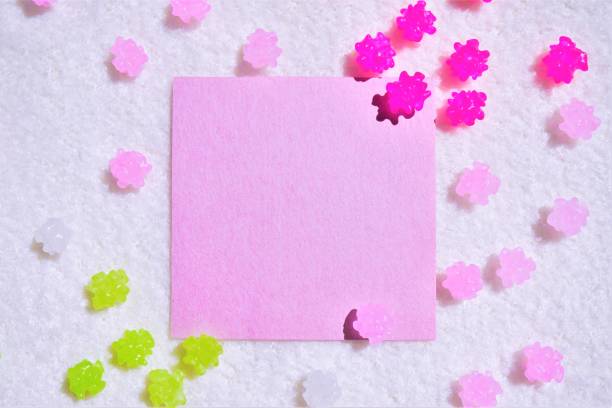 ふわふわの布地の白い背景にカラフルな紙吹雪ときれいなピンクの和紙を持つコメントスペースのモックアップ