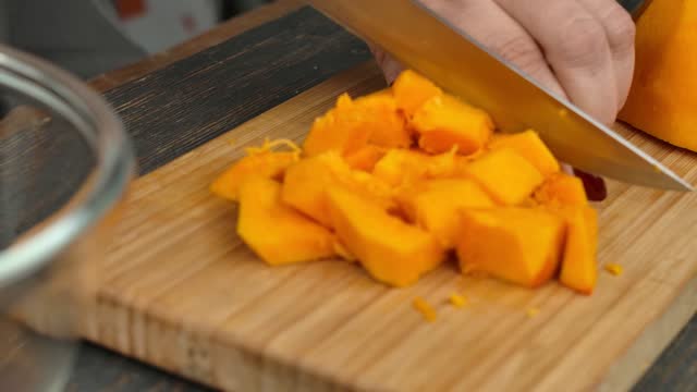 Knife cuts pumpkin slices into square pieces
