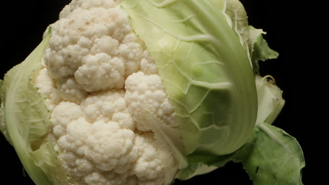 Cauliflower rotates , isolate close-up on a black background.