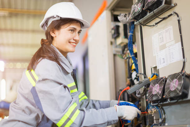 joven ingeniera feliz sonrisa prueba de mantenimiento de voltaje del cable de alimentación con servicio de alto voltaje fuente de alimentación de gabinete grande. - maintenance engineer industry asian ethnicity technology fotografías e imágenes de stock