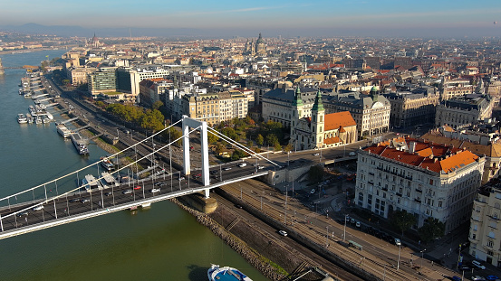 Aerial view of Budapest's city skyline on a sunny day, showcasing the elegant Elisabeth Bridge - the third newest bridge of Budapest, Hungary - which connects the charming Buda and Pest districts across the iconic River Danube. A picturesque sight of the city's stunning architecture and urban landscape.