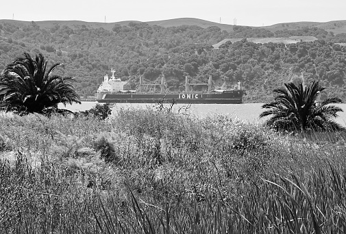 Cargo ship heading out to sea on hot day, from Benicia, North Bay, Northern California.  Image taken May 2023.