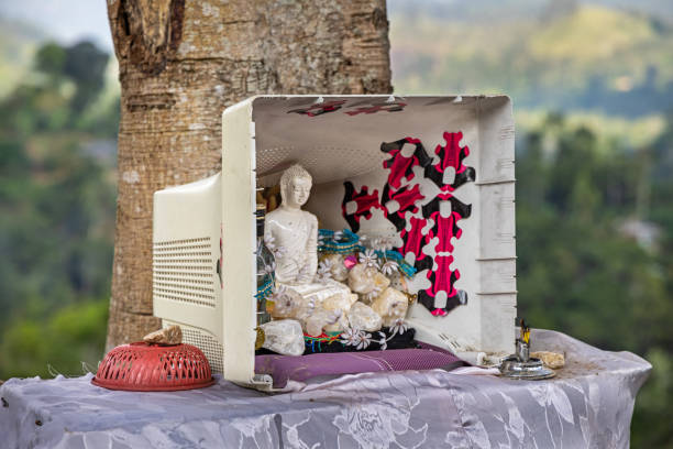 Kumbalwela, Uva Province, Sri Lanka - February 18th 2023:  Small Buddhist altar placed beside the road with a Buddha figure in a old computer monitor