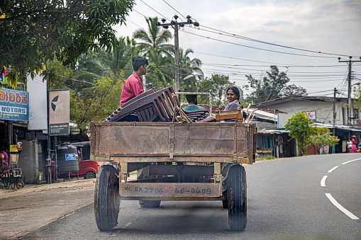 Dambulla, Central Province, Sri Lanka - February 27nd 2023:  People sitting in a tractor trailer with their belongings