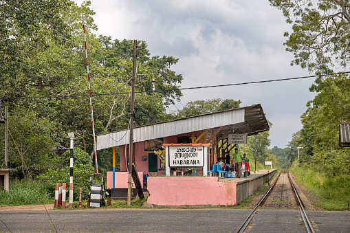 Habarana, North Central Province, Sri Lanka - March 2nd 2023:  The railway station with waiting passengers and a look down the single track