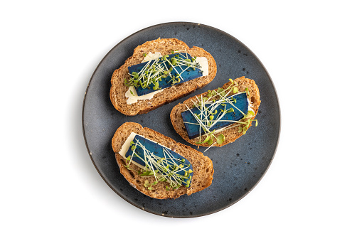Bread sandwiches with blue lavender cheese and mustard microgreen isolated on white background. top view, flat lay, close up.