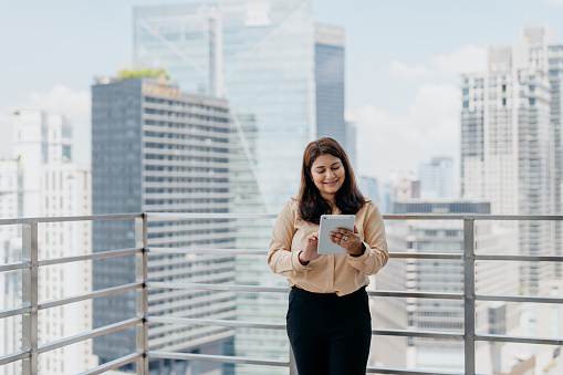 Asian Indian businesswoman using digital tablet in business financial district