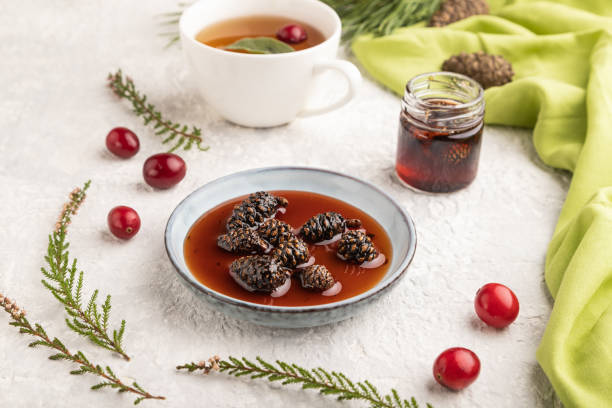 istock Pine cone jam with herbal tea on gray concrete, side view, selective focus. 1486516442