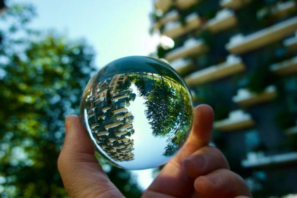 istock Crystal ball against trees and modern buildings 1486519299
