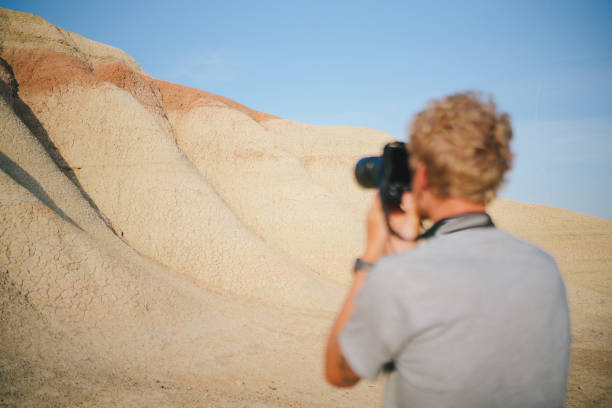istock Young man takes photos of distant mountains 1486519919