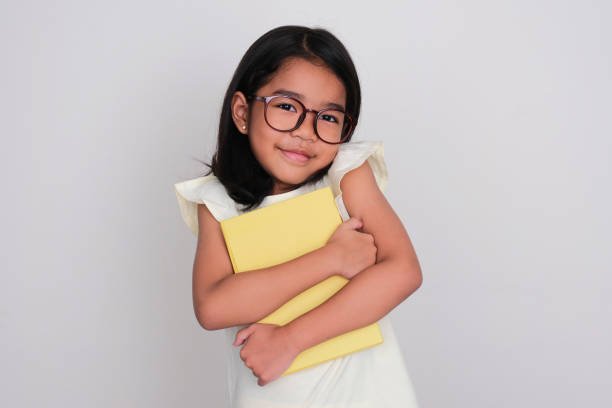 istock Asian kid smiling happy while hugging her school book 1486531896