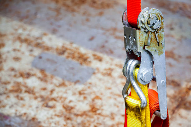 istock Tensioned cargo strap, orange, with ratchet lock, close-up. 1486532225