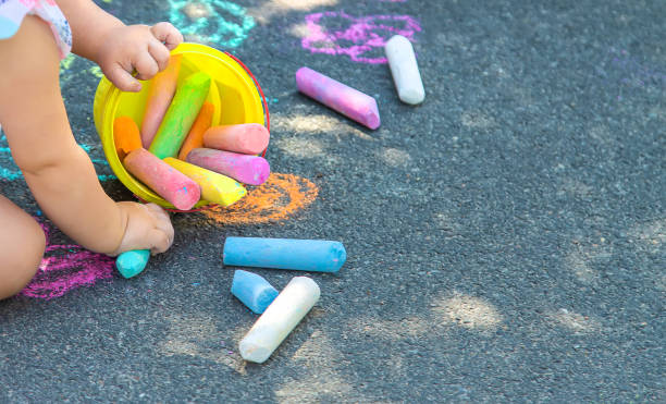 il bambino disegna con il gesso sull'asfalto. messa a fuoco selettiva. - little girls sidewalk child chalk foto e immagini stock