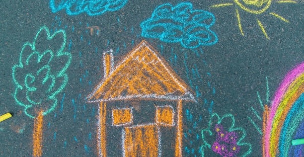 istock draws a house and a rainbow on the asphalt with chalk. Selective focus. 1486532293